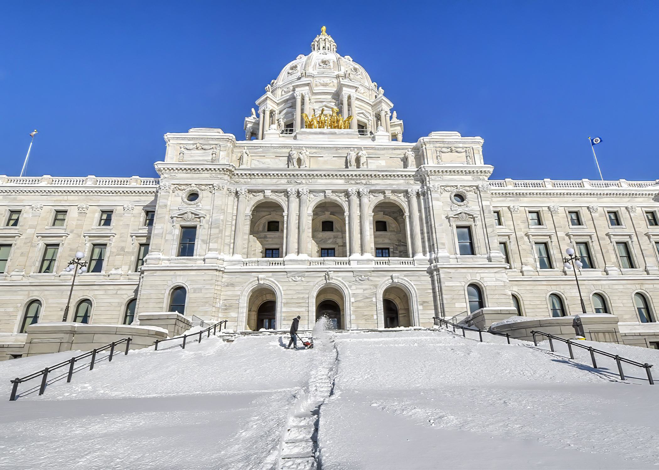 A groundskeeper makes a valiant effort to remove snow on the Capitol steps. Under a bill passed May 6 in the Minnesota House, January would be designated 'Snow Professionals Appreciation Month.' (House Photography file photo)